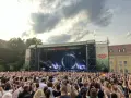 Ein riesiges Publikum feiert beim Citadel Music Festival in Berlin. Die Bühne ist beleuchtet, die Menge jubelt.