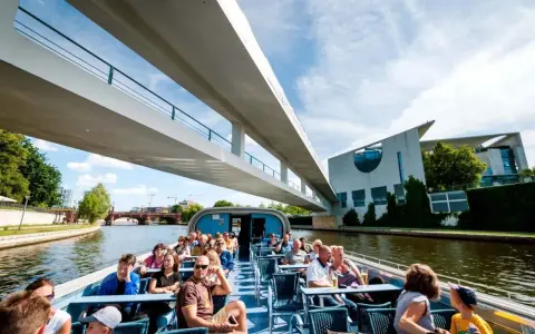 Bootsfahrt auf der Spree in Berlin unter einer modernen Brücke mit Blick auf das Regierungsviertel.