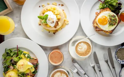 Ein köstlicher Brunch in Berlin: Pancakes mit Früchten, Eggs Benedict und Croque Madame mit Spiegelei. Dazu Kaffee und Saft.
