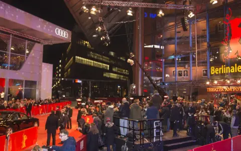 Roter Teppich vor dem Berlinale Palast, wo die Stars bei den Filmfesten in Berlin eintreffen. Menschenmassen und Kameras warten auf die Ankunft.