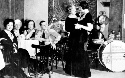 Tanzpaar in einem Berliner Nachtclub, Berlin 1920. Musiker im Hintergrund, Gäste an Tischen.