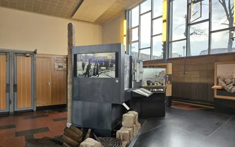 Ausstellung im "Palace of Tears" Berlin: Ein Stein, ein Bildschirm mit historischem Bild, und Ausstellungsstücke erinnern an die Teilung.