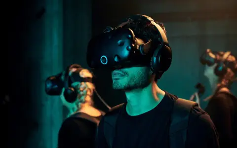 Mann mit VR-Brille bei VR Nation Berlin, taucht in virtuelle Welten ein.