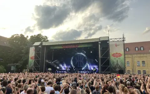 Ein riesiges Publikum feiert beim Citadel Music Festival in Berlin. Die Bühne ist beleuchtet, die Menge jubelt.