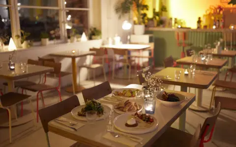 Gemütliche Tische mit Essen und Kerzenlicht im Blumental Berlin.