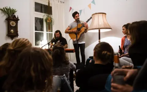 Gemütliches souly konzert berlin. Zwei Musiker spielen Gitarre und Keyboard, während das Publikum zuhört.