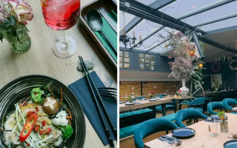 Ein Gericht mit Hühnchen und Gemüse, daneben ein Getränk. Im Hintergrund ein stilvolles Restaurant mit Spree-Blick.