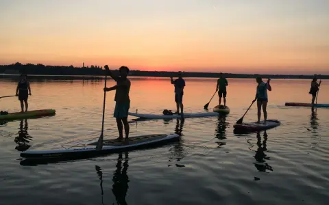 Sonnenuntergang über Berlin: Eine Gruppe genießt Wassersport auf Stand-Up-Paddle-Boards.
