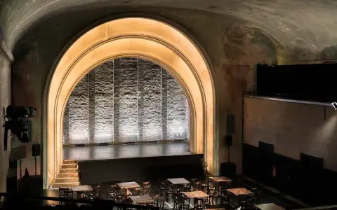 Das **Theater im Delphi** mit seiner beeindruckenden Bogenarchitektur und der beleuchteten Bühne lädt zu unvergesslichen Vorstellungen ein.