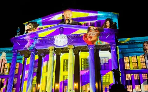 Das Konzerthaus Berlin erstrahlt in bunten Farben bei der "Berlin Nacht der Lichter". Gesichter und Muster projiziert auf die Fassade.