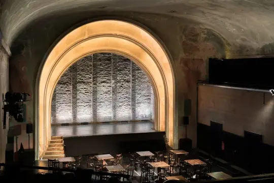 Das **Theater im Delphi** mit seiner beeindruckenden Bogenarchitektur und der beleuchteten Bühne lädt zu unvergesslichen Vorstellungen ein.