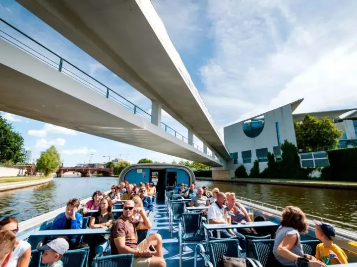 Bootsfahrt auf der Spree in Berlin unter einer modernen Brücke mit Blick auf das Regierungsviertel.