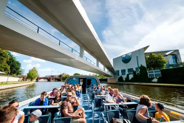 Bootsfahrt auf der Spree in Berlin unter einer modernen Brücke mit Blick auf das Regierungsviertel.
